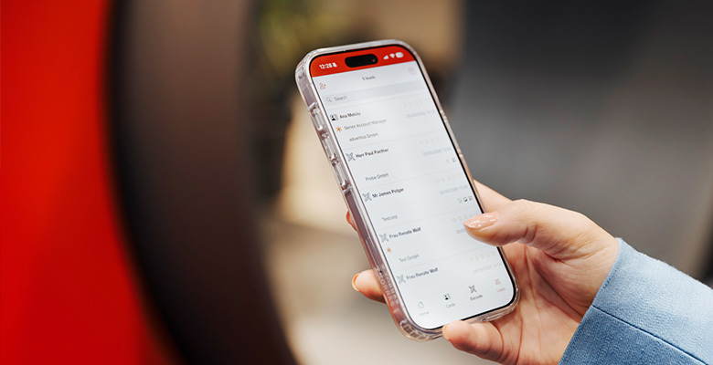 Hand hält ein Smartphone mit der übersichtlichen Lead-Liste der Scan2Lead App – Sinnbild für die intuitive Bedienung.
