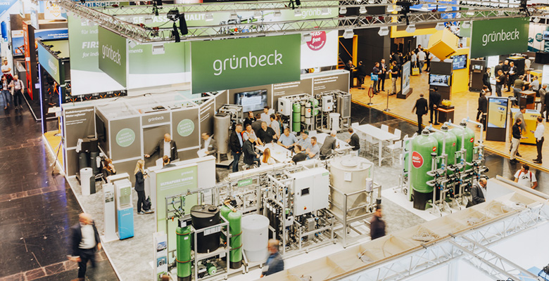 Großer Messestand mit Besuchern auf einer Fachmesse.