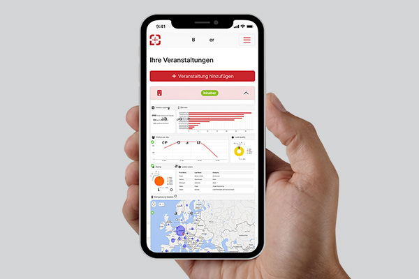 Hand hält ein Smartphone mit dem Scan2Lead PORTAL – Ansicht der Veranstaltungen mit Karte; Daten werden ins PORTAL hochgeladen und ausgewertet."